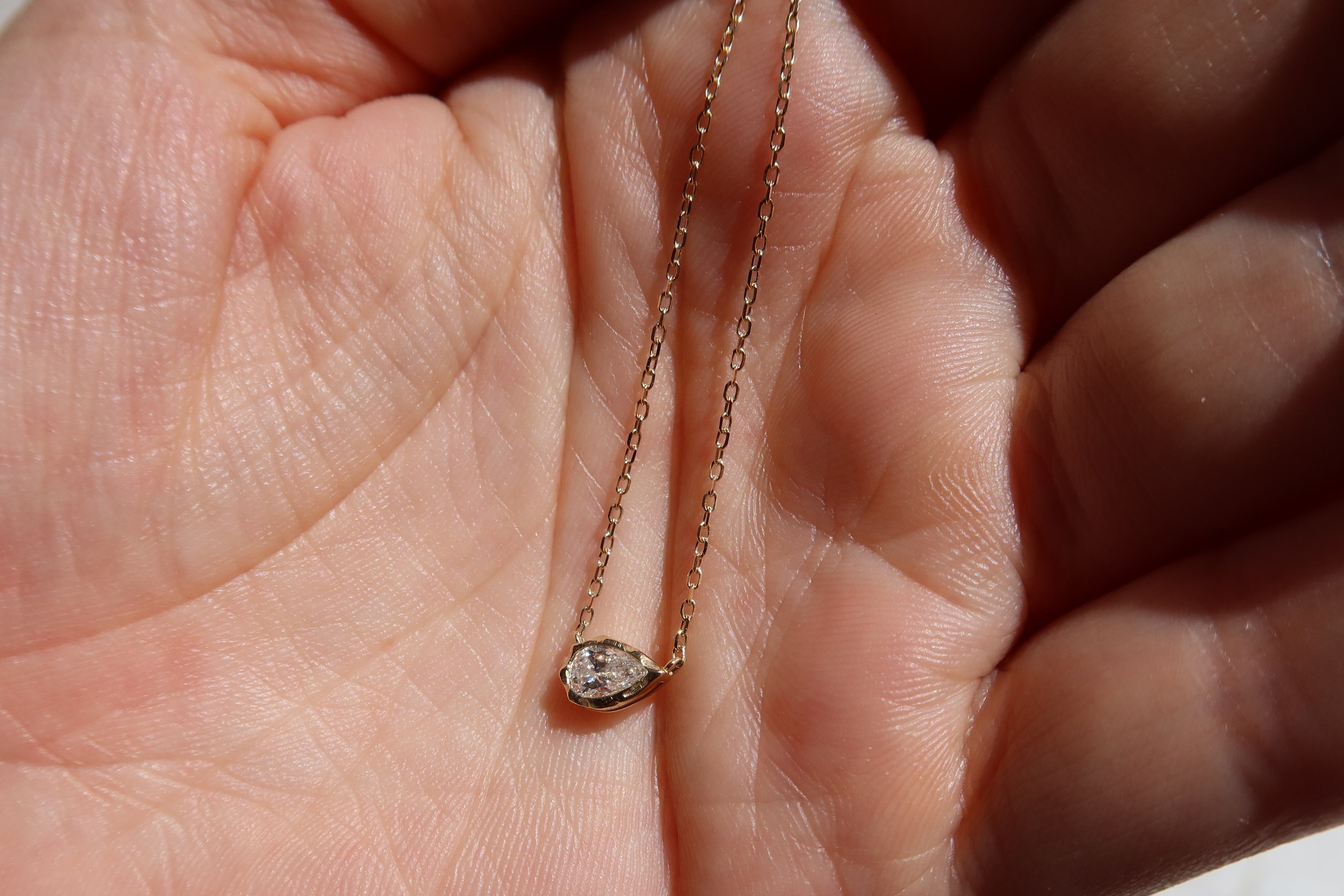 melted pear diamond bezel necklace in 10 karat yellow gold
